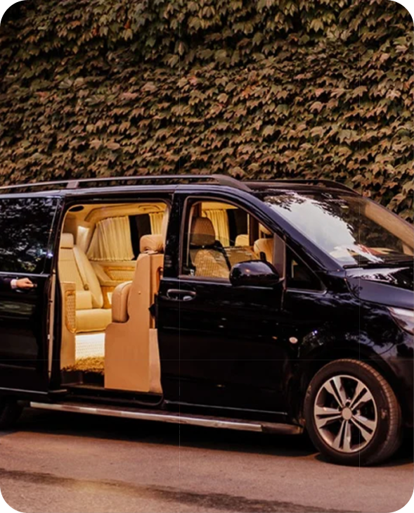 Luxury black van with open sliding door revealing beige leather interior, used for patient transportation at BlueMagic Clinic.